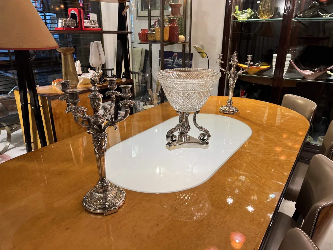 antique vase with elegant shape and ornamental details, surrounded by silver candlesticks on a table