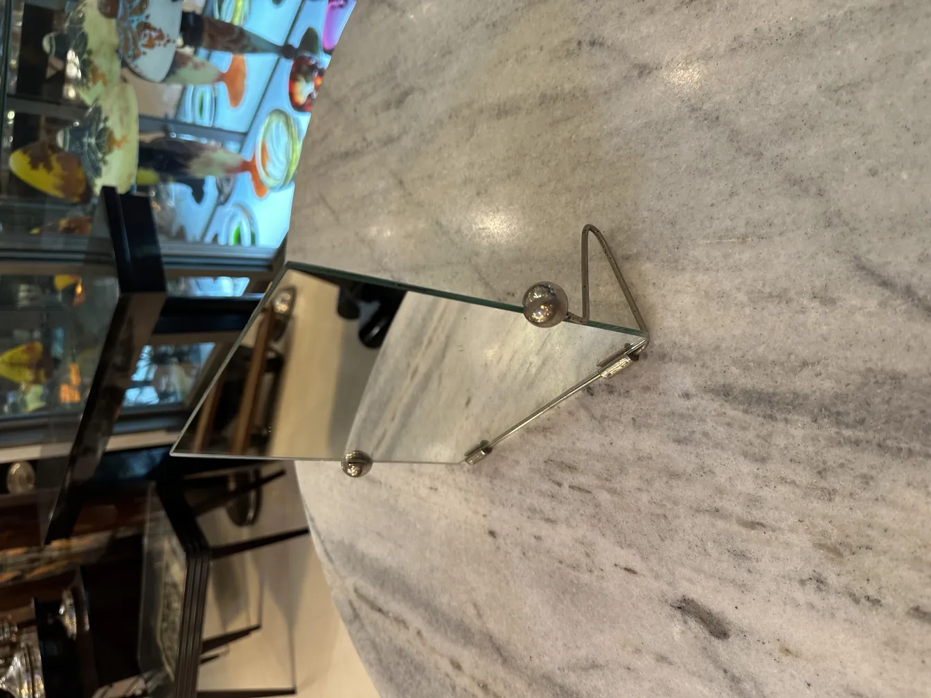 espelho antigo com suporte, refletindo detalhes do ambiente