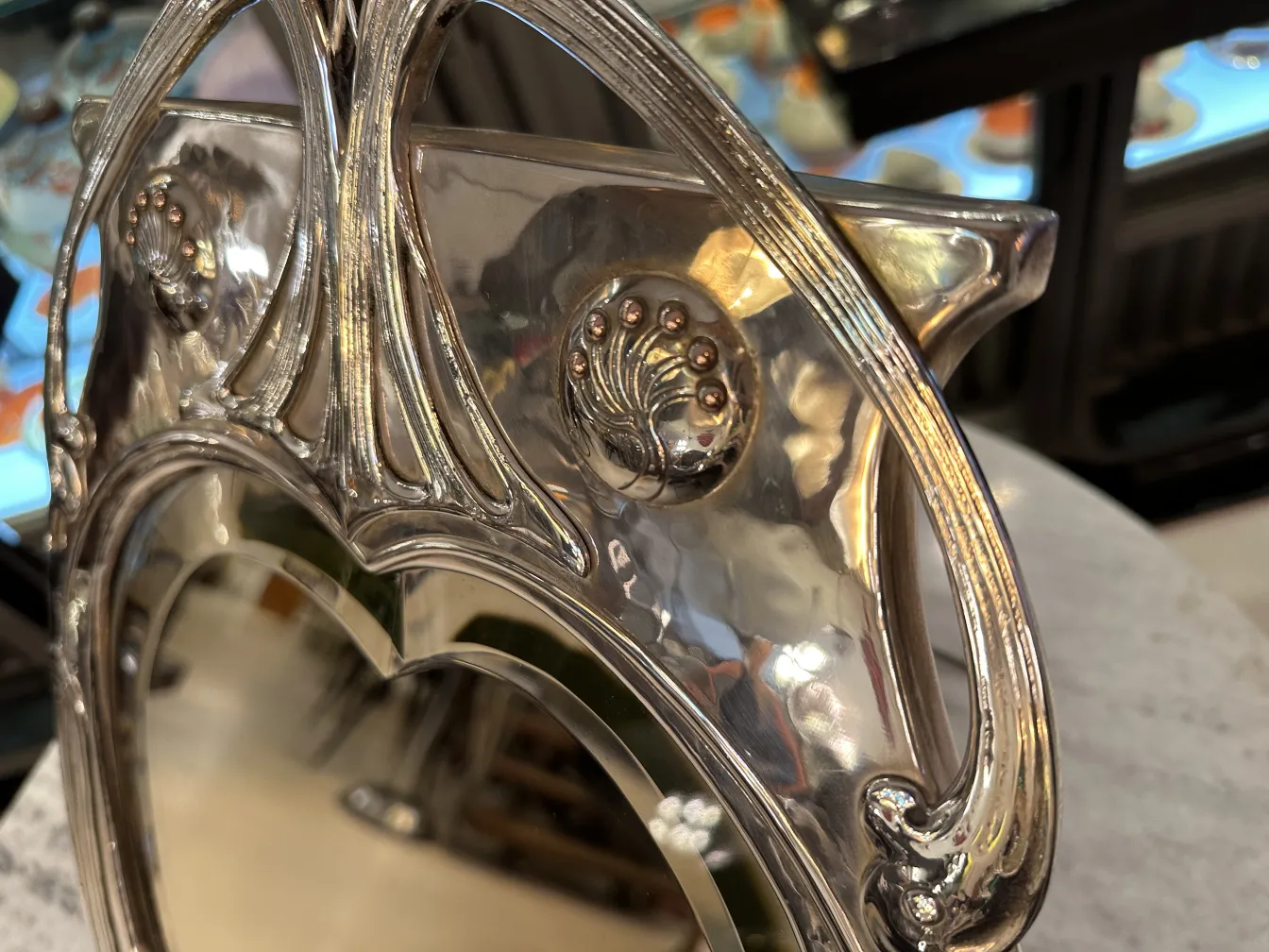 Espejo antiguo con diseño Art Nouveau y detalles decorativos.