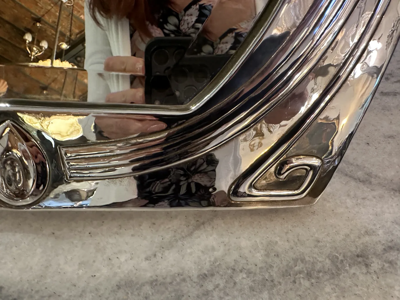 古い鏡はエレガントなアールヌーヴォーデザインで飾られています