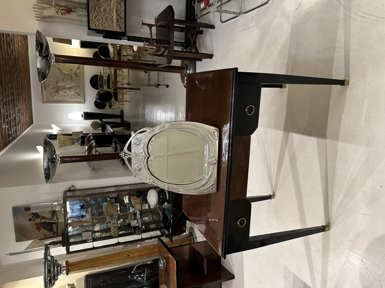 Espejo antiguo con marco artístico en una mesa elegante.