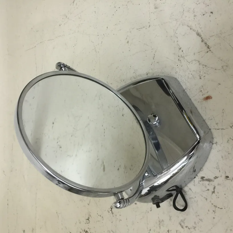 Miroir antique de salle de bain avec cadre rond et base argentée.