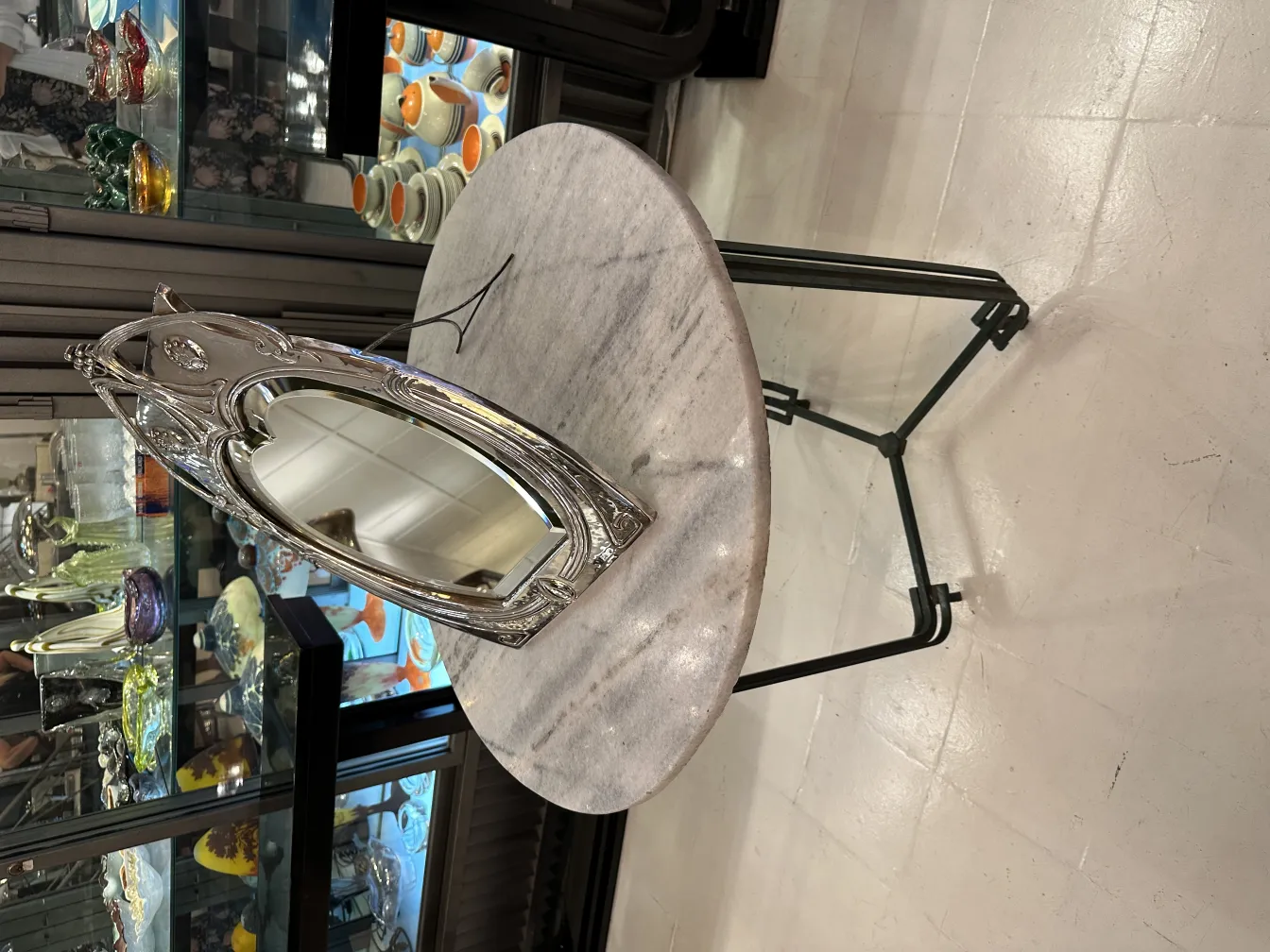 miroir ancien avec cadre décoratif en forme de feuille dans un environnement élégant