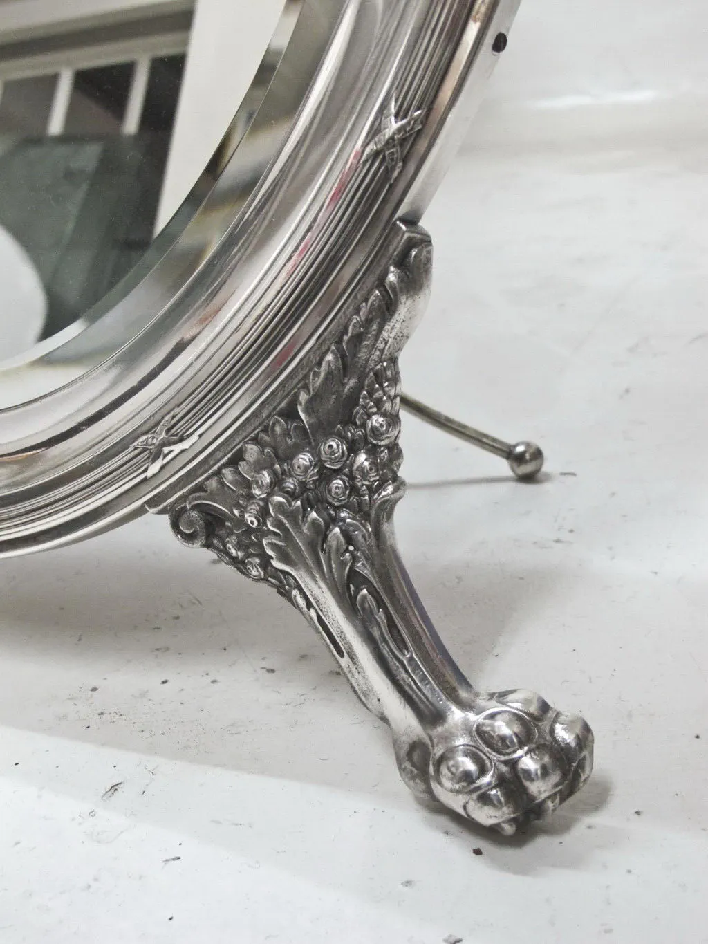 Miroir ancien avec des détails complexes à la base.