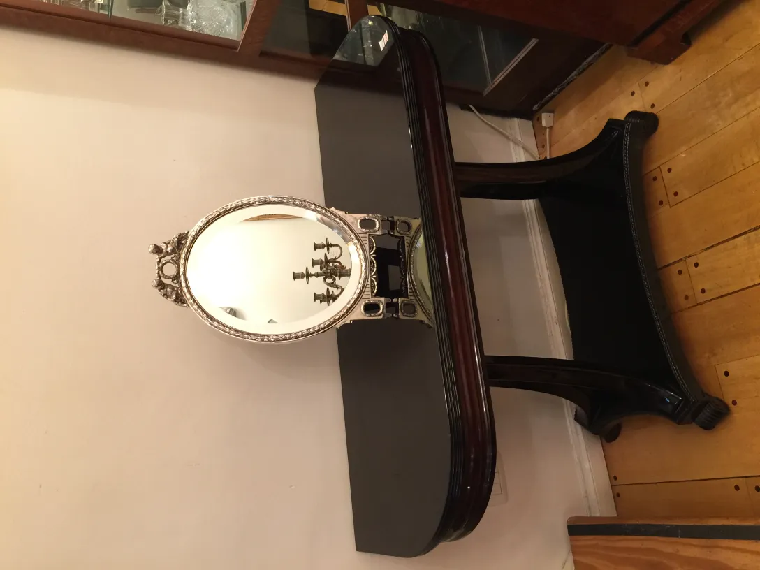 Antikes Spiegel mit verzierter Basis in eleganter Umgebung.