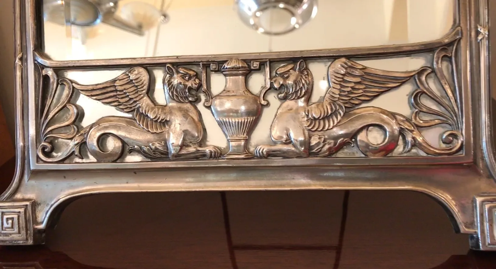 specchio antico con decorazioni in stile Art Nouveau, che riflette un ambiente elegante.