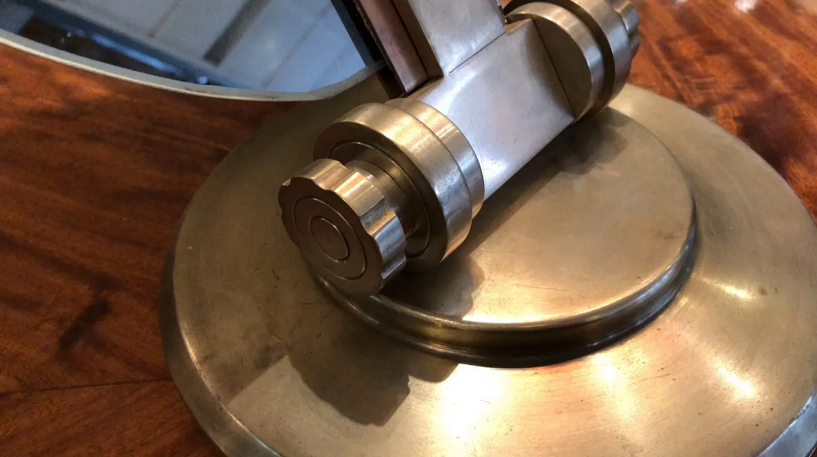 Espejo antiguo con elegante mecanismo y base redonda en madera