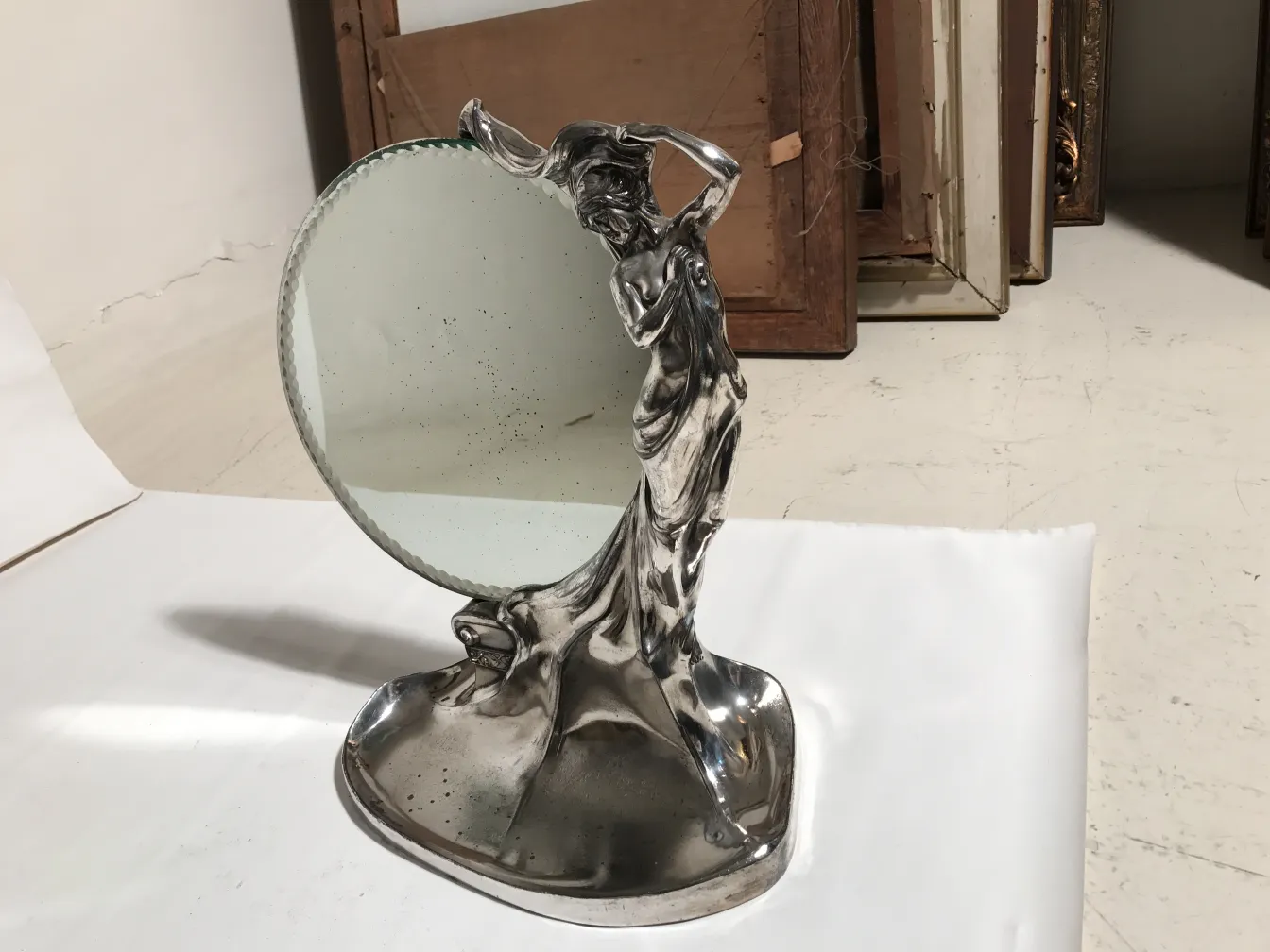 Espelho antigo Art Nouveau com figura estilizada em suporte, fundo neutro