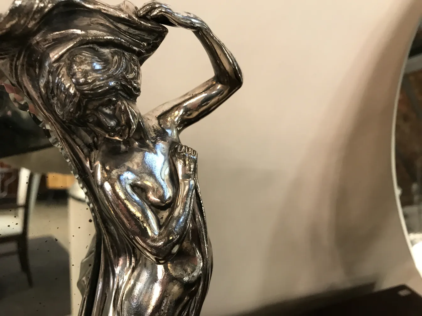 espejo antiguo con detalle femenino en el marco