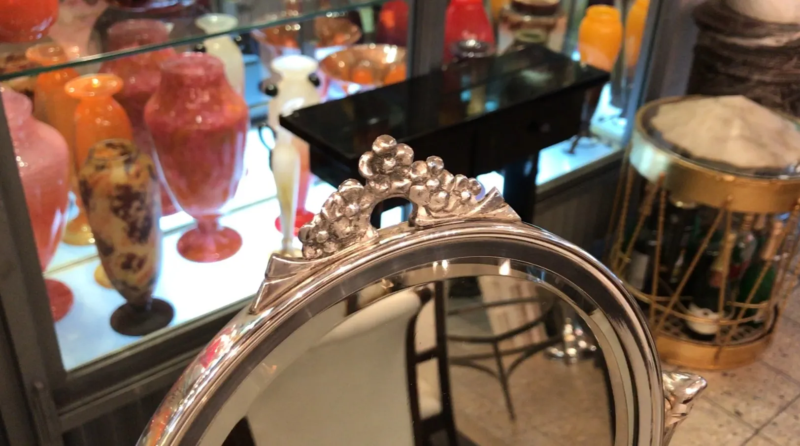 miroir antique avec des détails floraux en haut, dans un cadre ancien