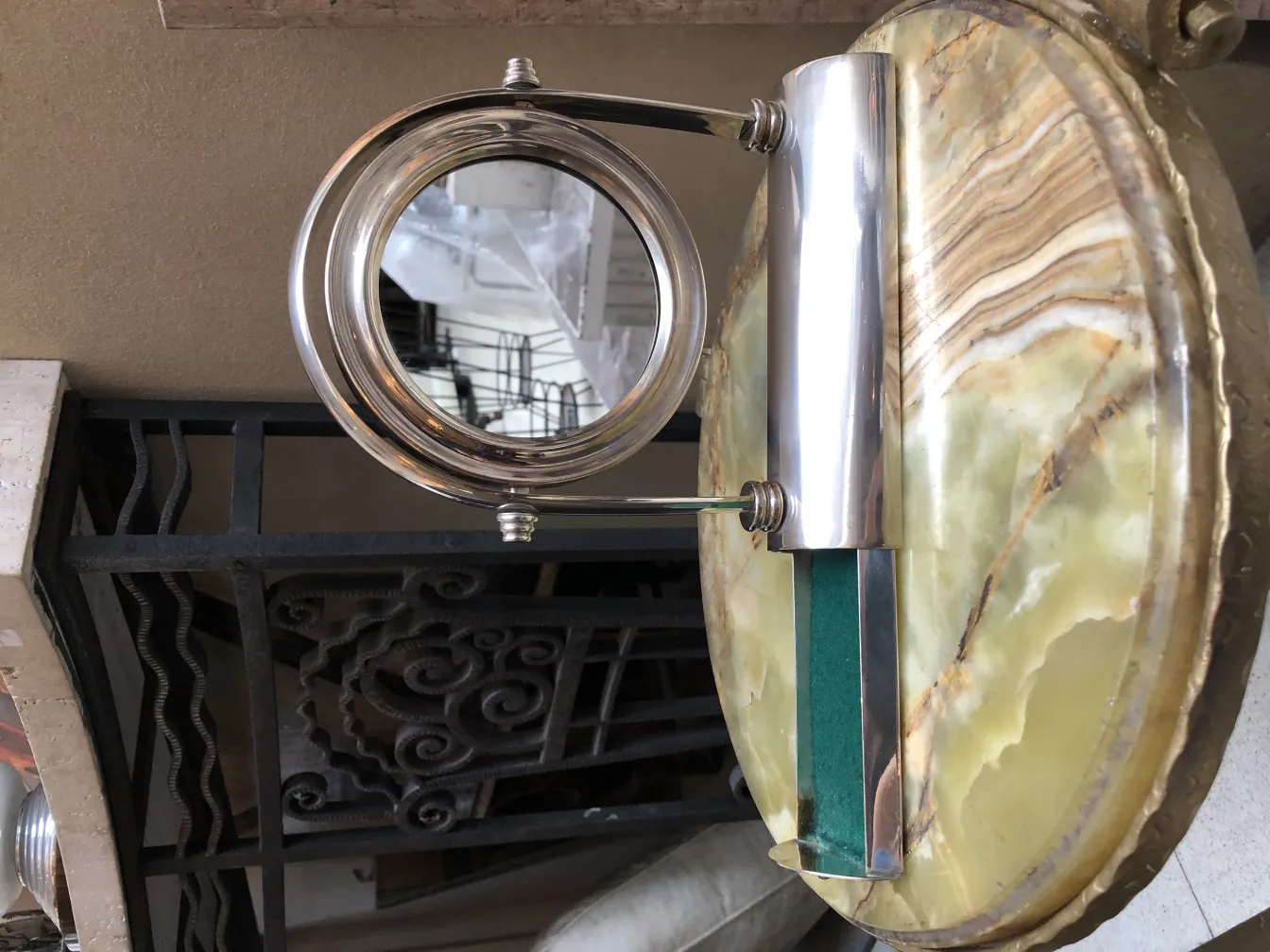 antique mirror with elegant design and artistic base, placed on a decorative surface.