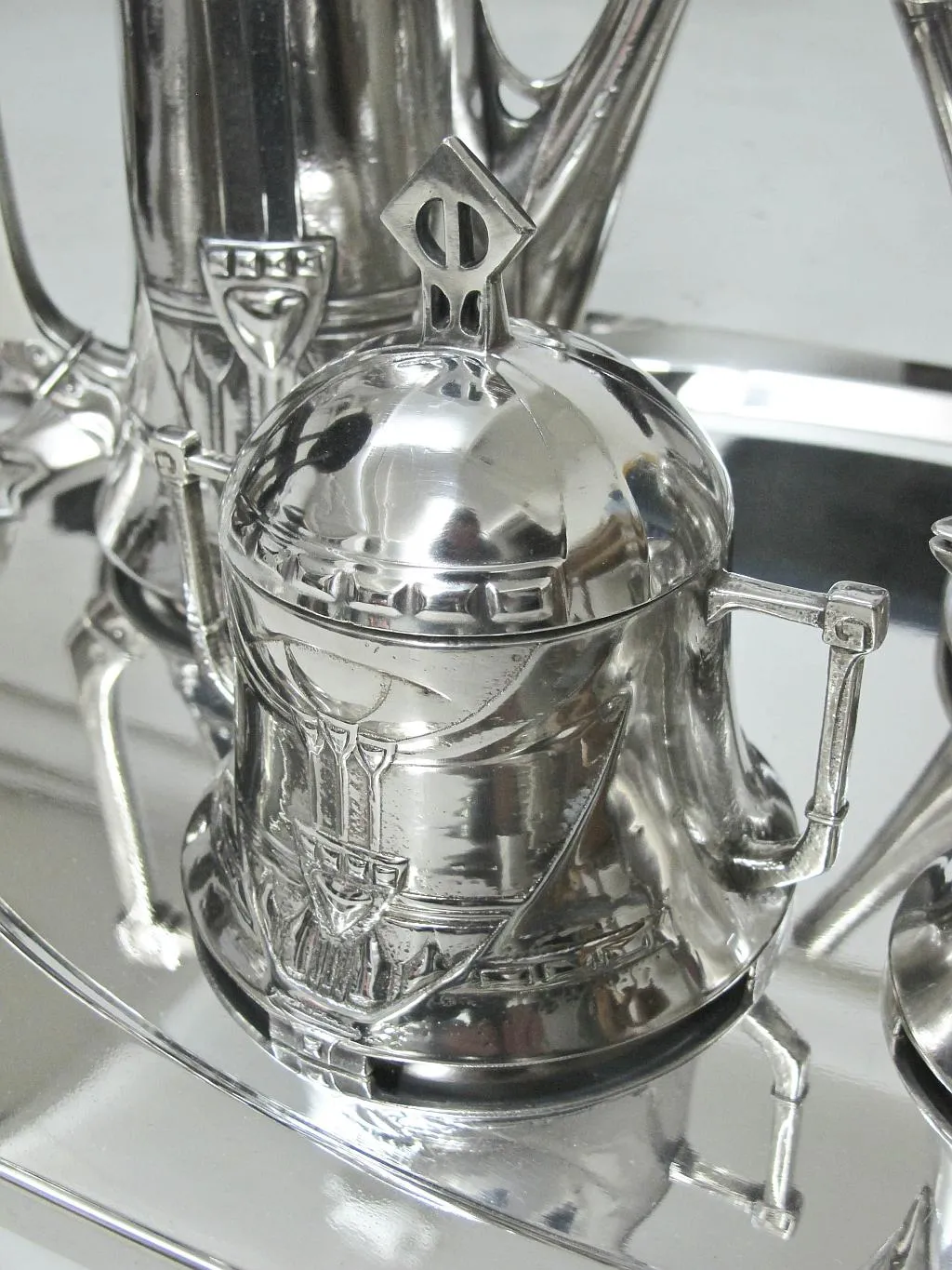 Juego de té antiguo WMF con detalles decorativos claros, presentado en un ambiente elegante.