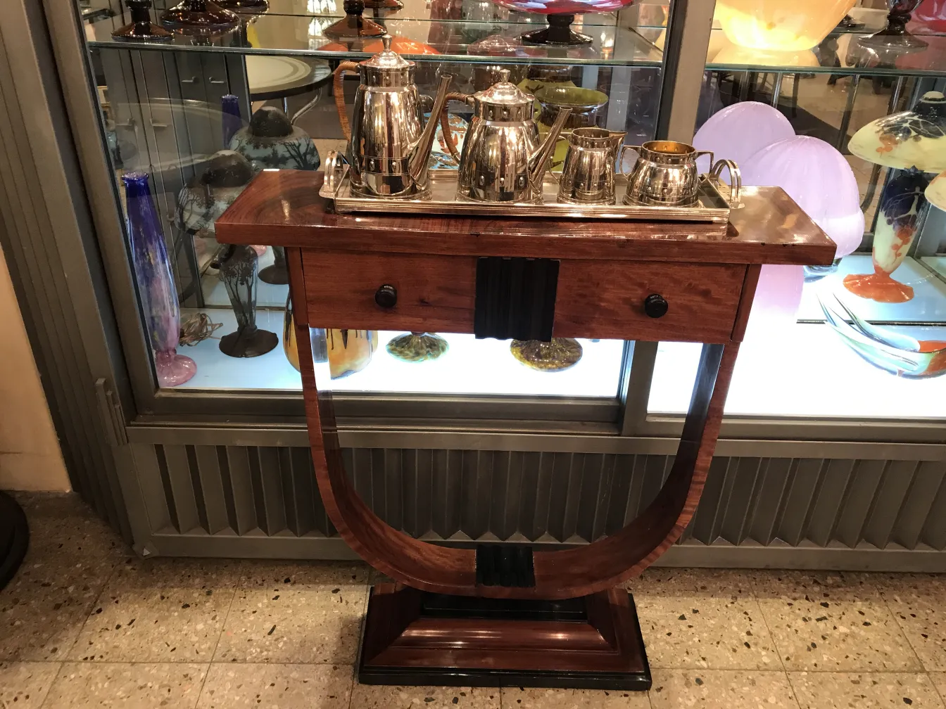 Juego de té antiguo WMF sobre una mesa decorativa con elementos secundarios de vidrio de colores