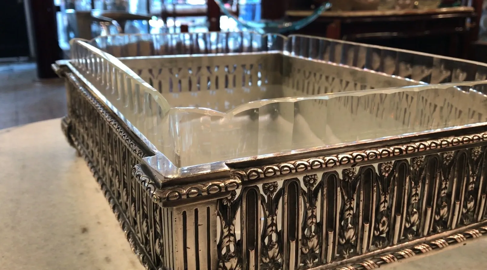 centro de mesa antigo Christofle com detalhes decorativos intrincados em ambiente antiquado