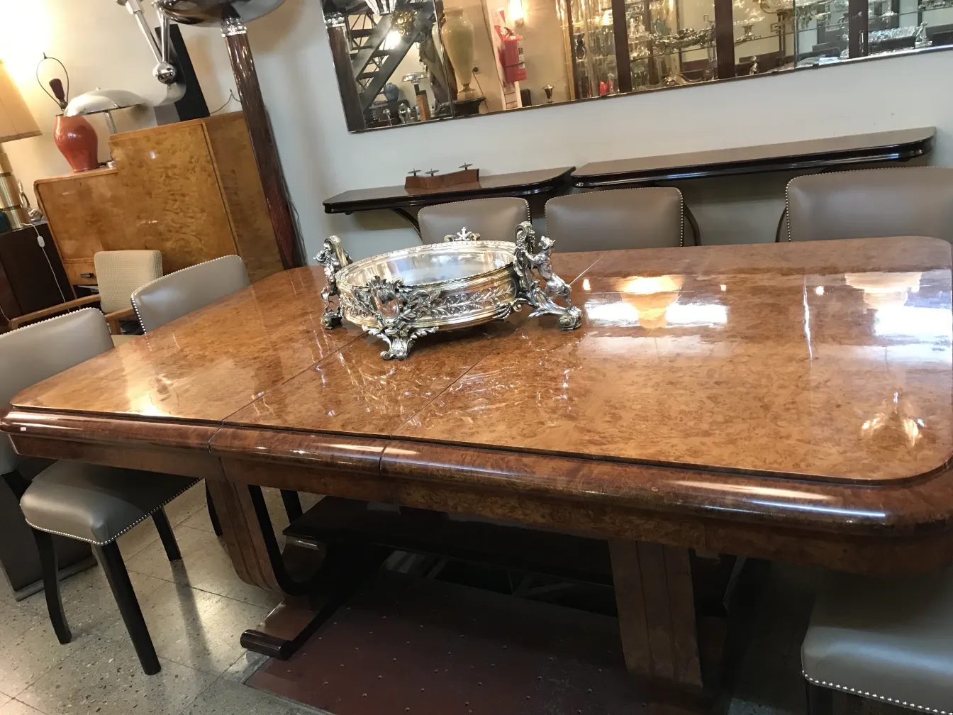 antique centerpiece Christofle on a wooden table, with dark chairs in the background.