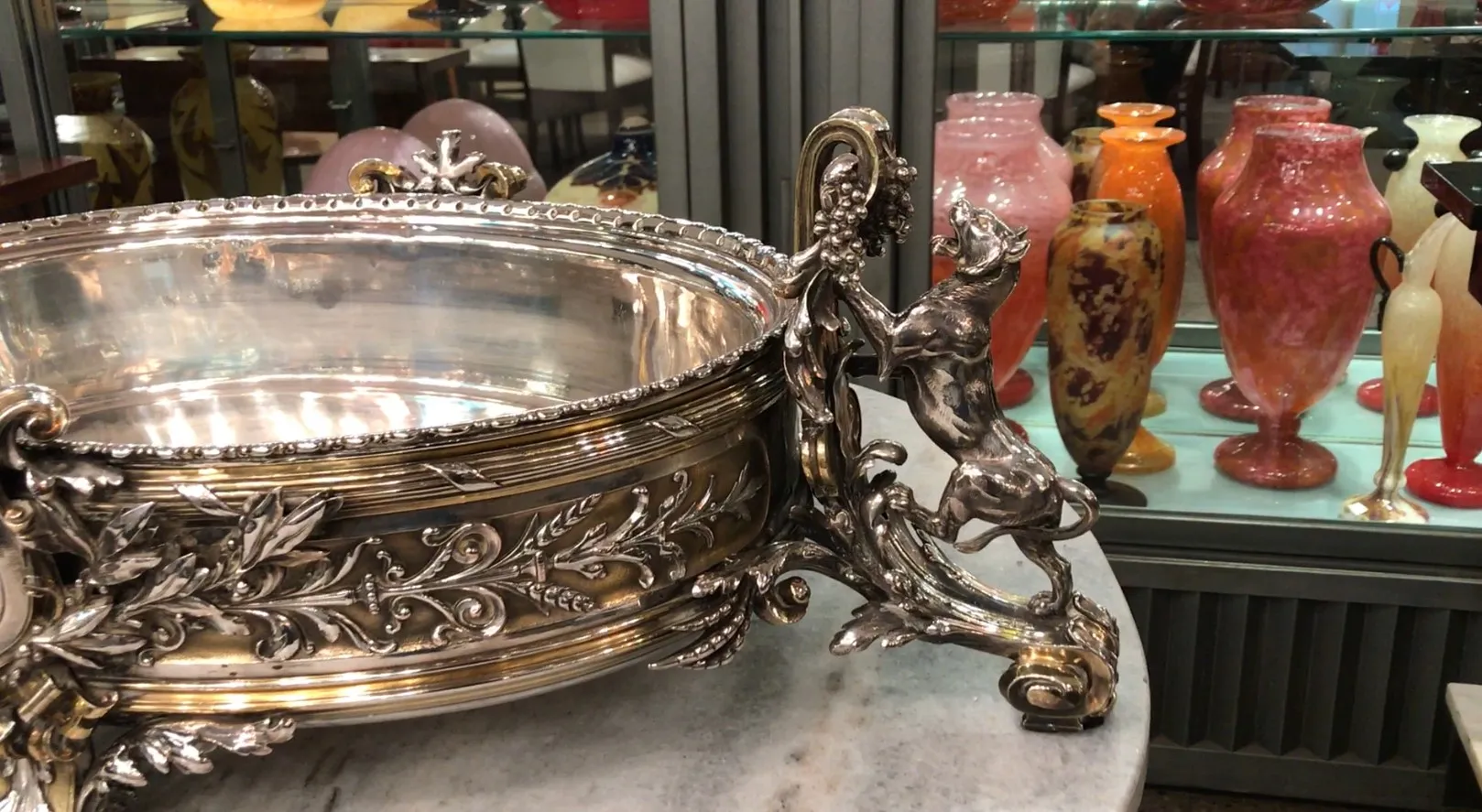 centre de table ancien Christofle avec design décoratif et détails ornés, arrière-plan avec des vases colorés.