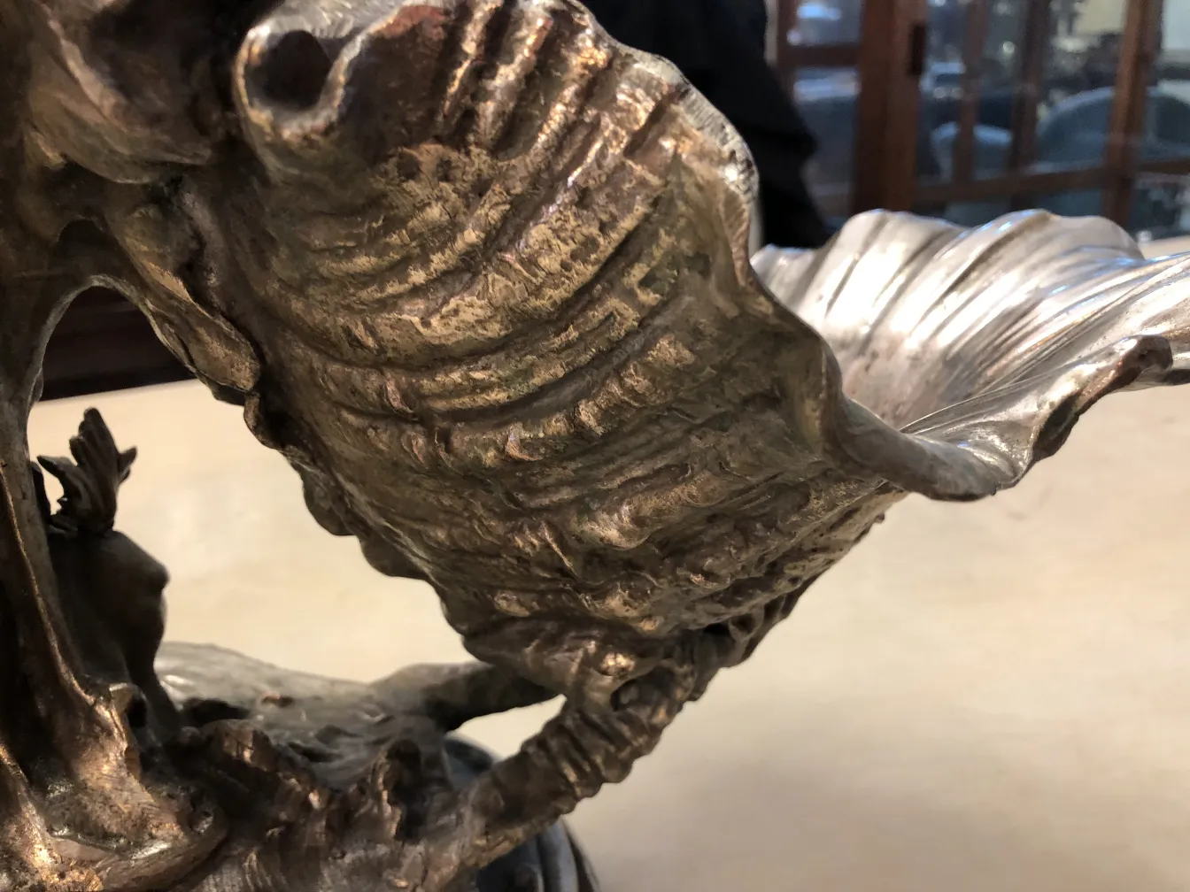 قطعة مركزية أثرية مزينة بقاعدة مزخرفة معقدة في بيئة كلاسيكية.