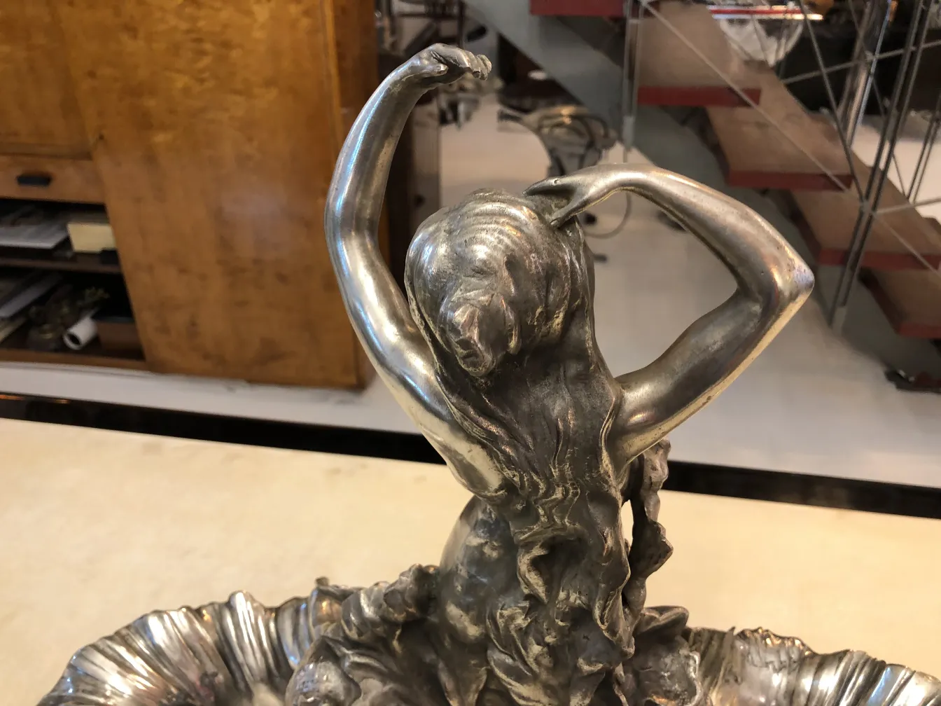 centrotavola antico con figura femminile e dettagli decorativi