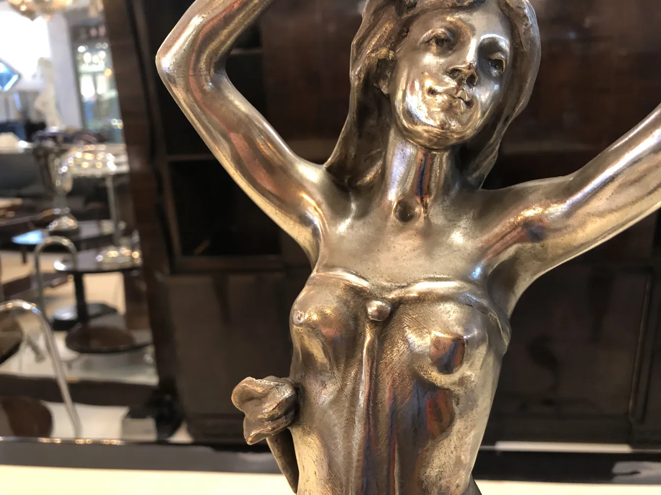 centro de mesa antigo com figura feminina em um ambiente elegante