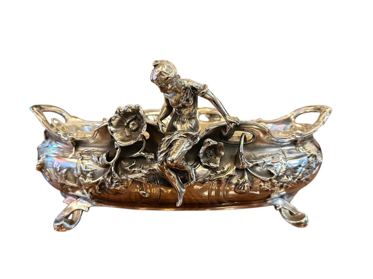 Antiker blumentopf mit figur, verziert mit blumen.