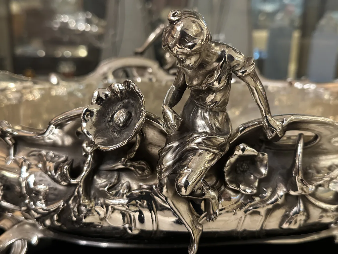 पुरातन केंद्र सजावट जिसमें फूल और उभरी आकृति है