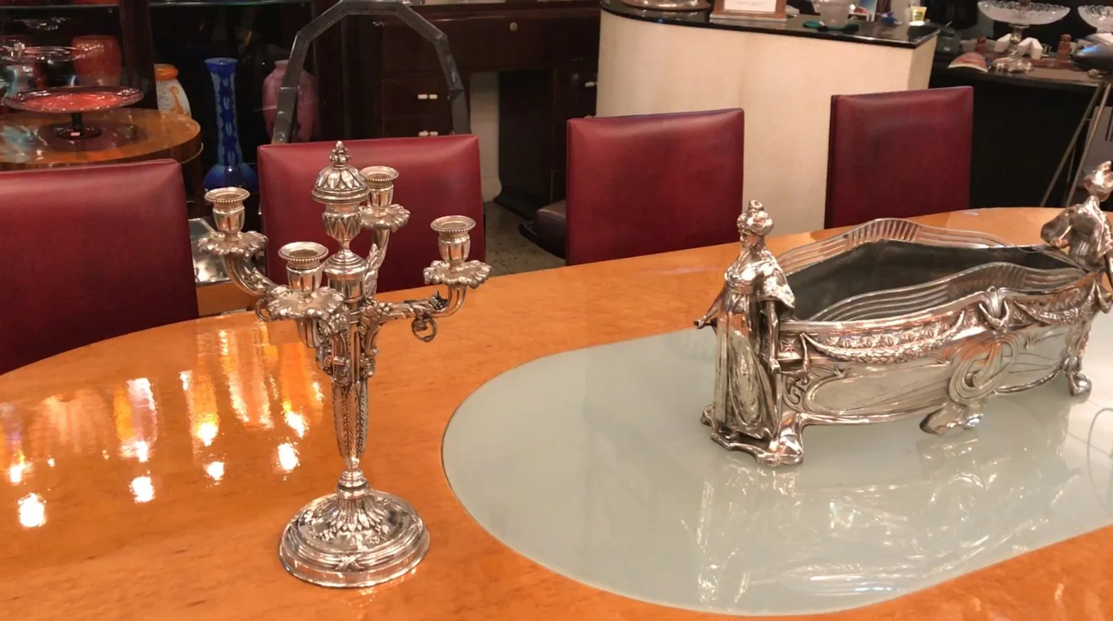 Centro de mesa antigo WMF exibindo elegância ao lado de um candelabro.