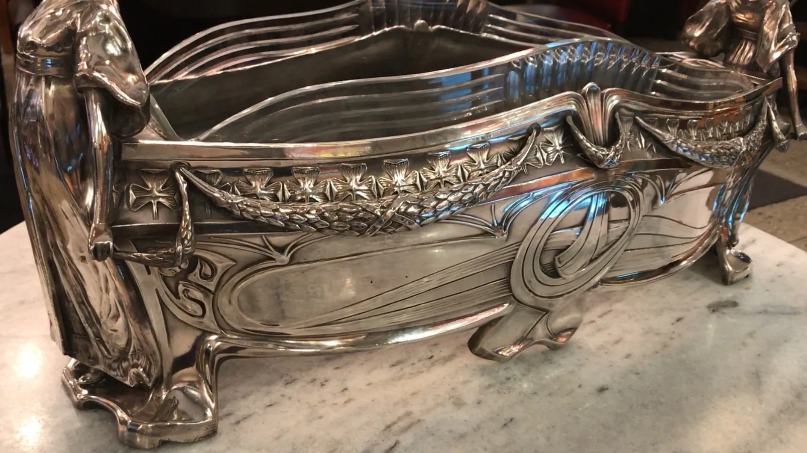 WMF centerpiece with ornamental details and decorative figures, on a light marble surface