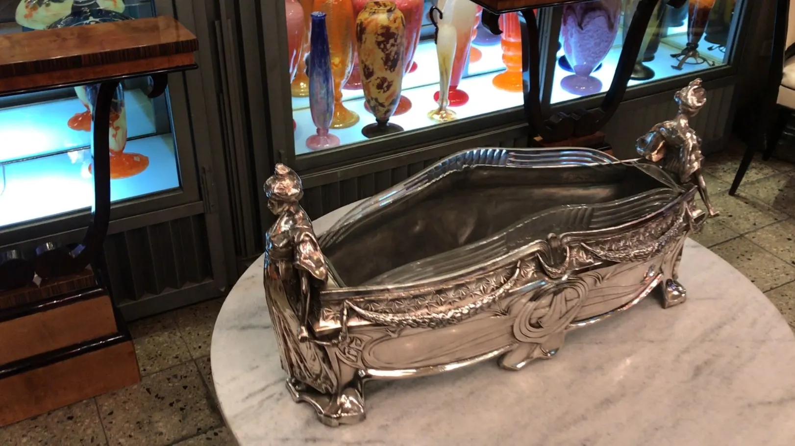 पुरातन WMF टेबल सजावट दोनों सिरों पर सजावटी आकृतियों के साथ, सफेद सतह पर