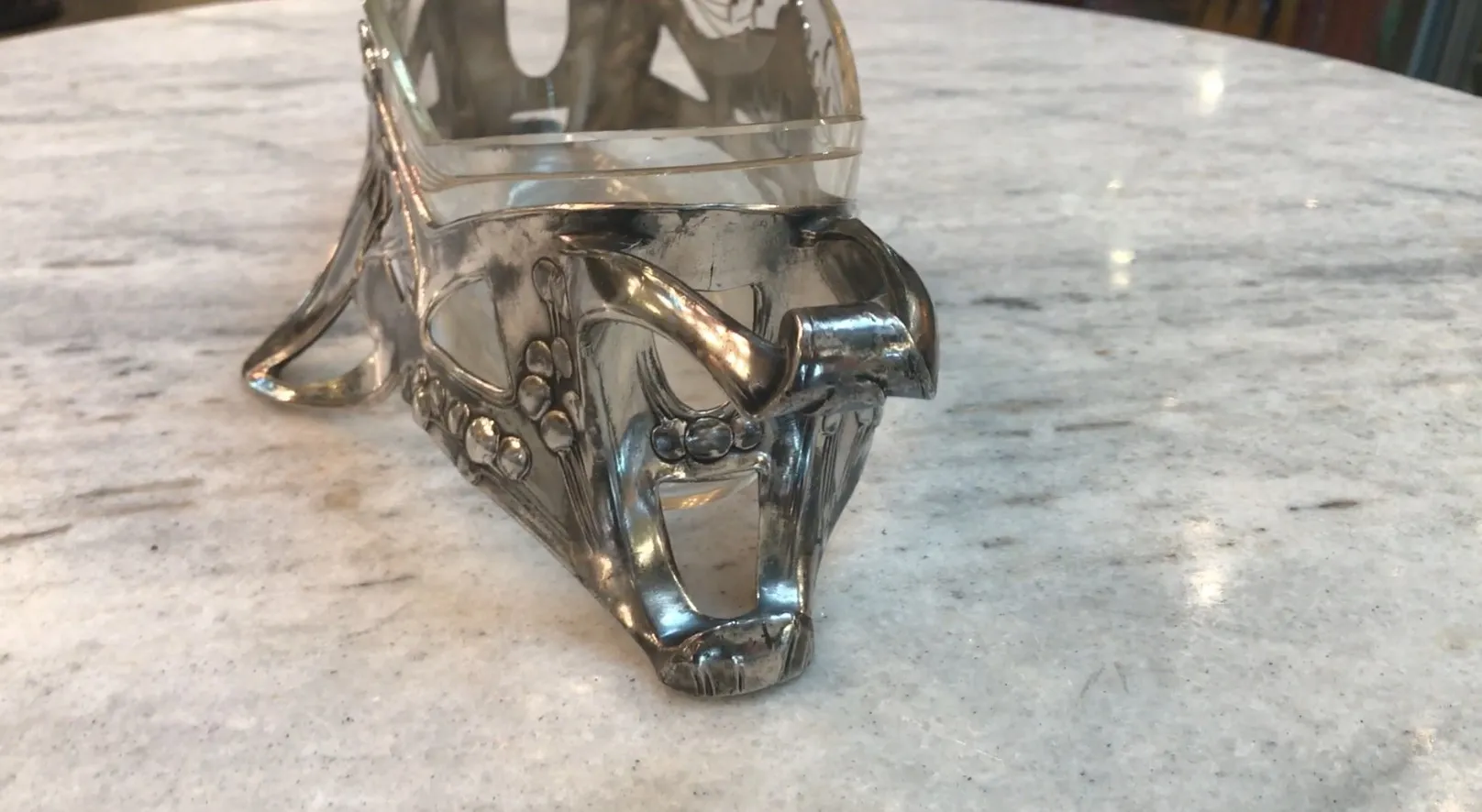 古いWMFセンターピースが明るい大理石の背景の上にあります。