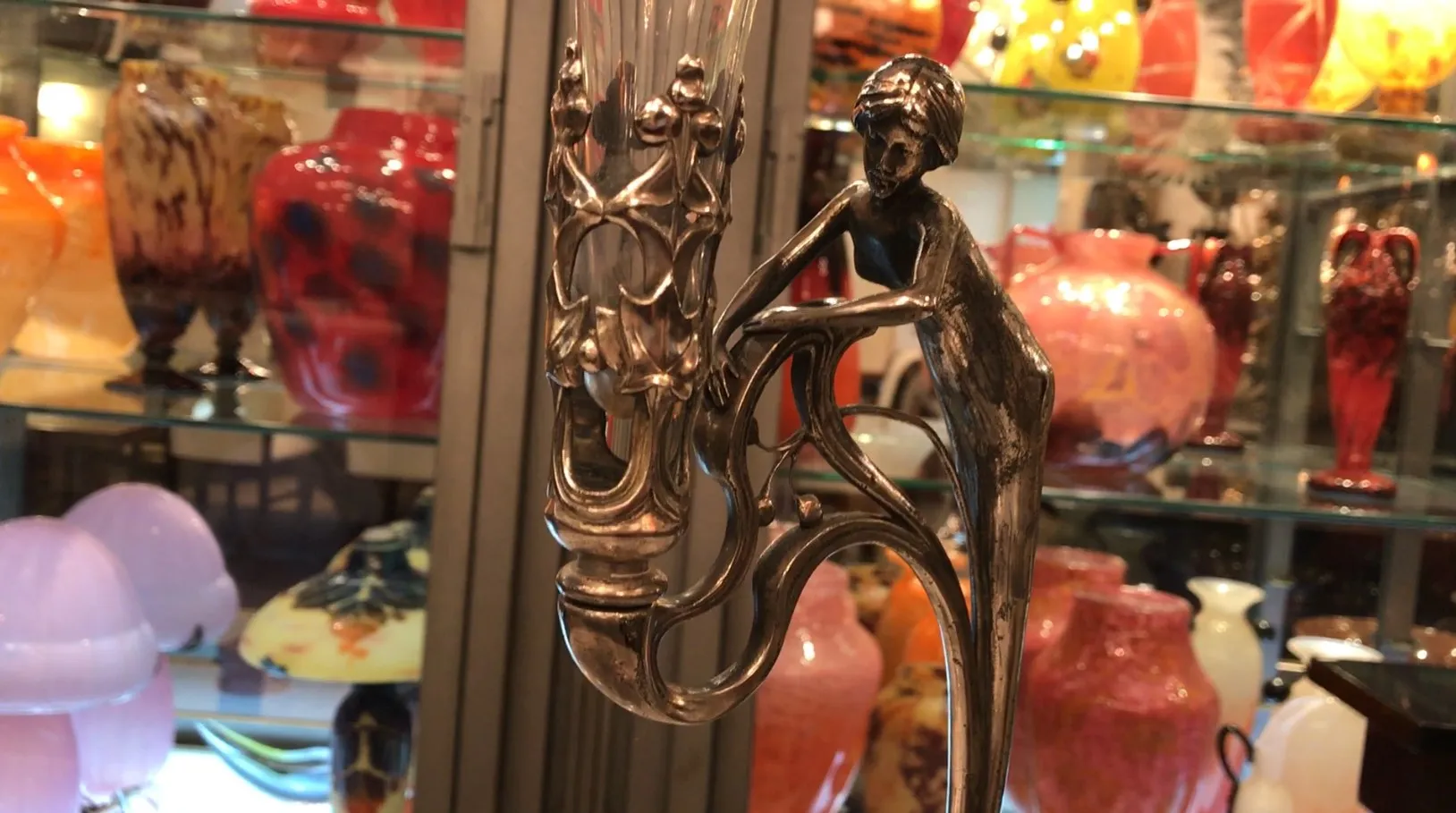 Antique WMF centerpiece with decorative figure in a colorful setting.