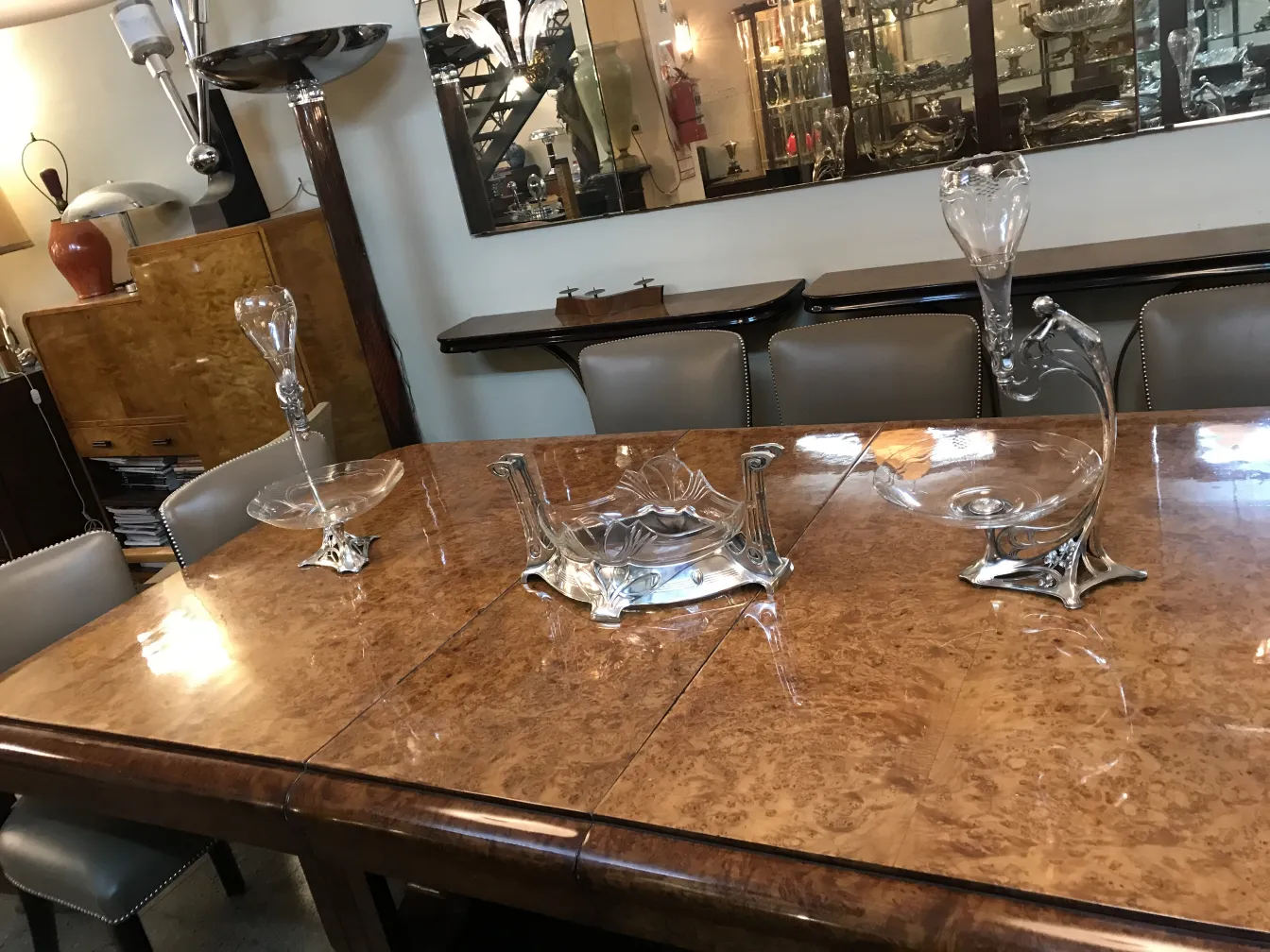 Antique WMF centerpiece on wooden table, surrounded by decor.