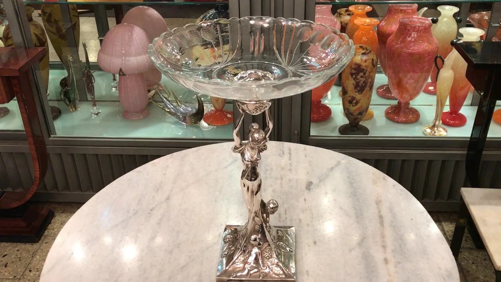 Centro de mesa antigo WMF com base decorativa e estilo clássico, em ambiente de antiguidade.