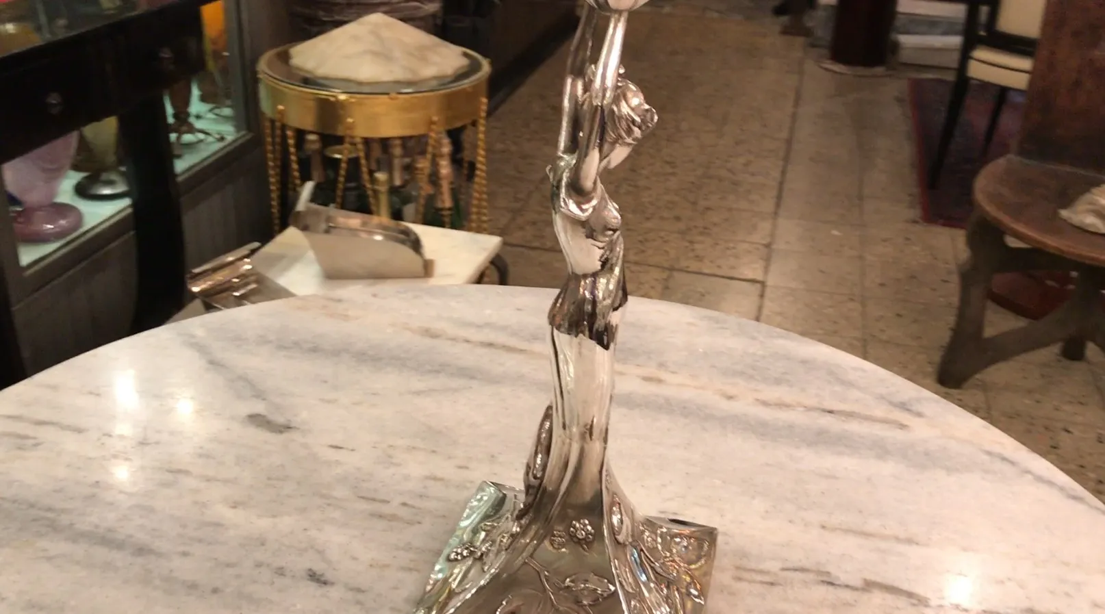 centrotavola WMF antico con figura decorativa elegante, atmosfera calda, dettagli floreali