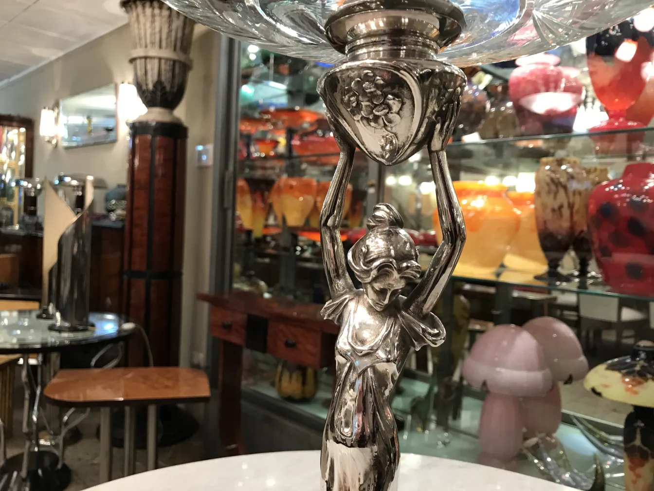 centrotavola antico WMF con figura decorativa e sfondo colorato