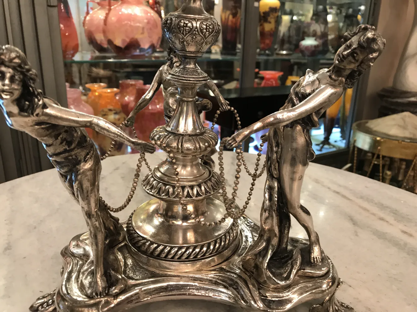 antique wmf centerpiece with human figures and chain in a decorative setting