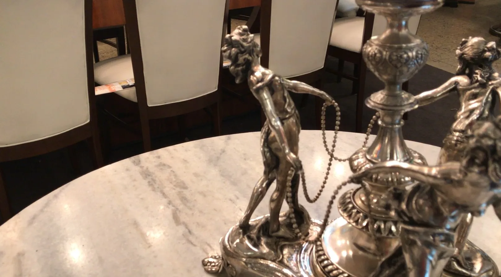 Centro de mesa WMF antigo com figuras em um ambiente elegante