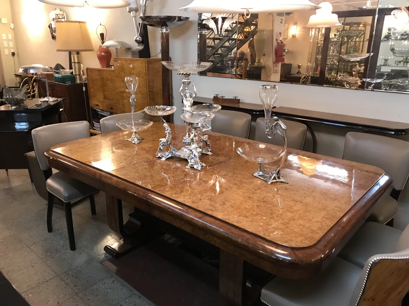 Centro de mesa antigo WMF adornando uma mesa elegante, cercado por cristais e móveis antigos.