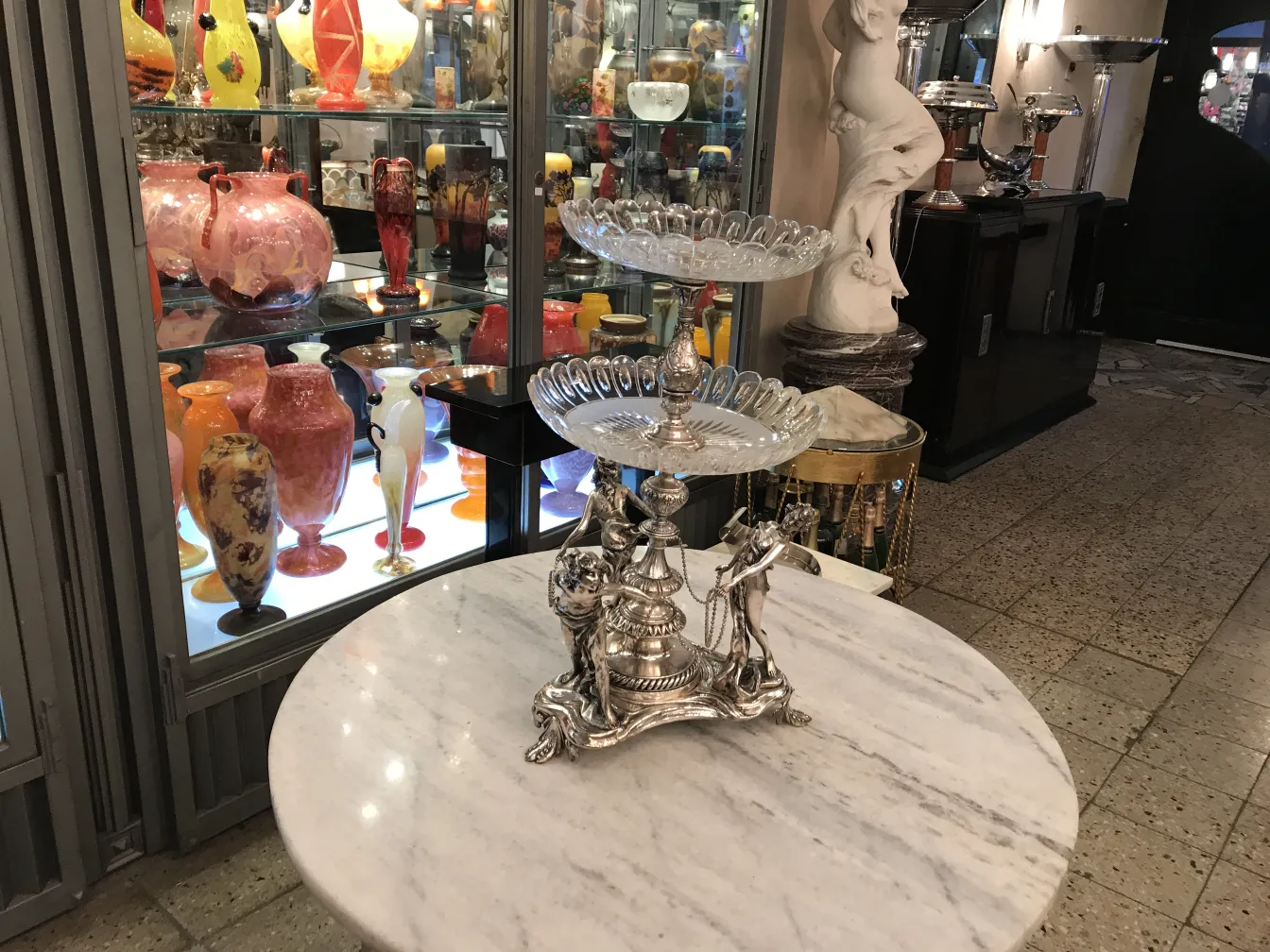 古董中心装饰品放在大理石桌上，背景是五颜六色的花瓶