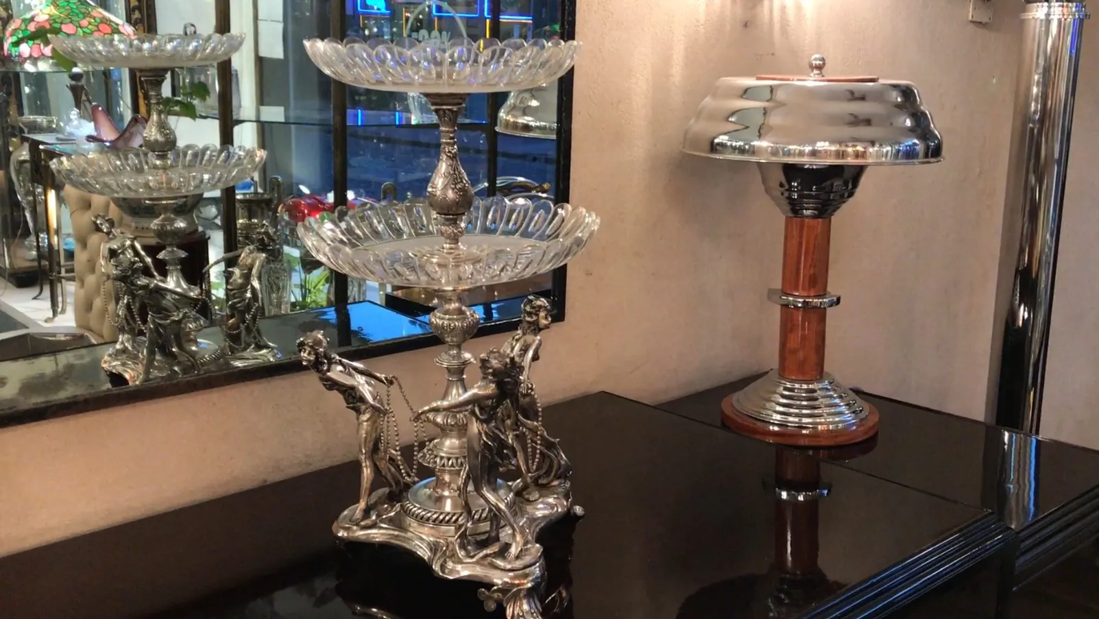 Centro de mesa WMF antigo com figuras decorativas, em um ambiente elegante.