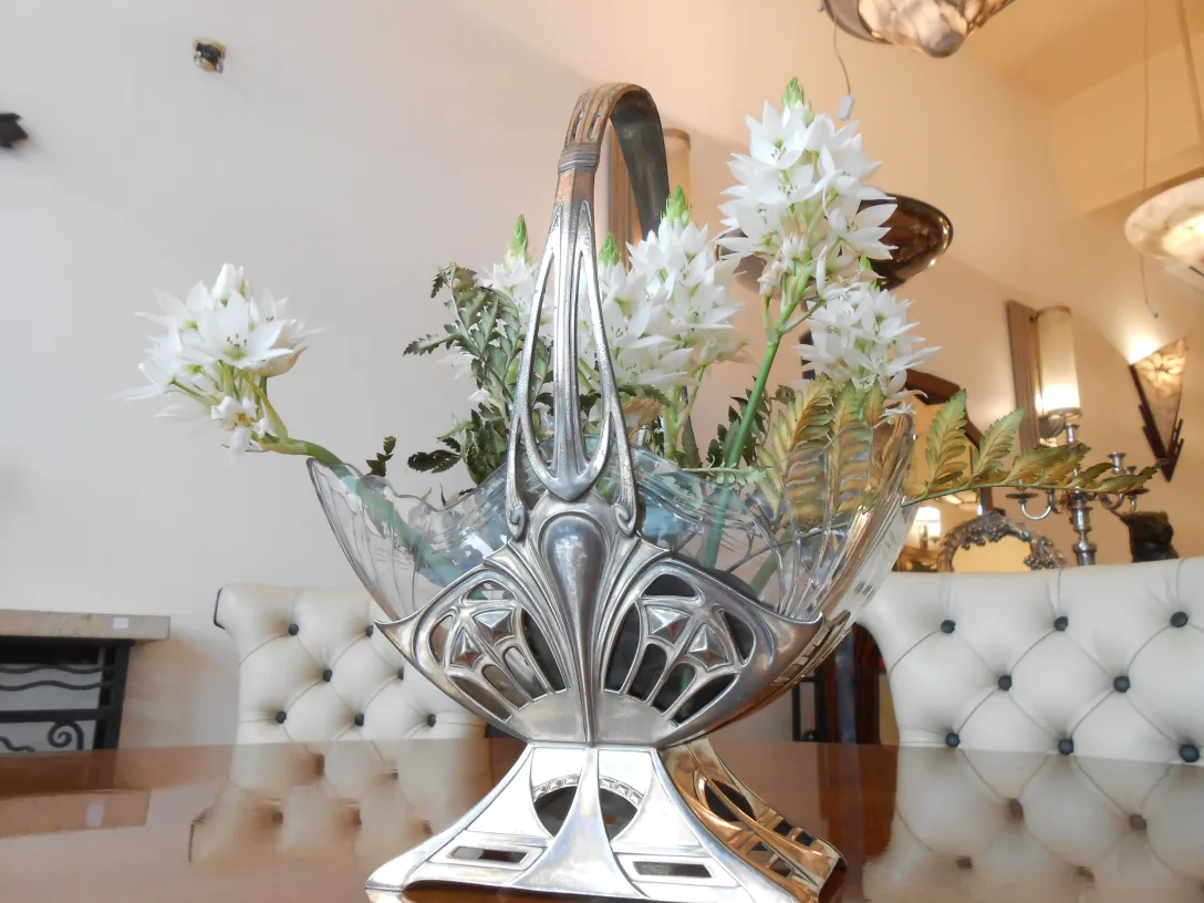 antikert design WMF mit weißen Blumen und grünen Blättern in einem eleganten Umfeld