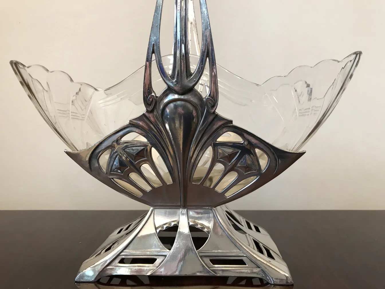 Antico centrotavola WMF con design elegante e forme curve, circondato da un'atmosfera classica.