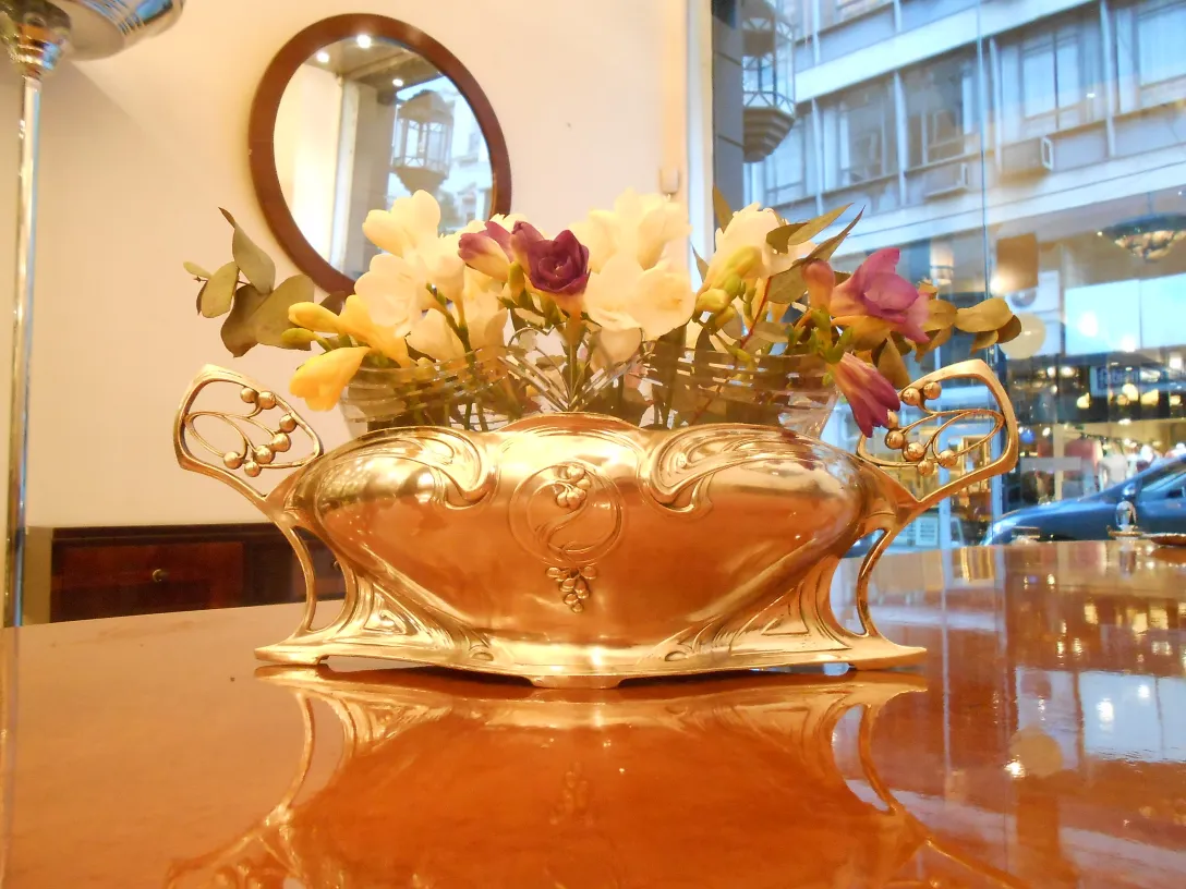 Centrotavola WMF antico con fiori colorati in un ambiente elegante.