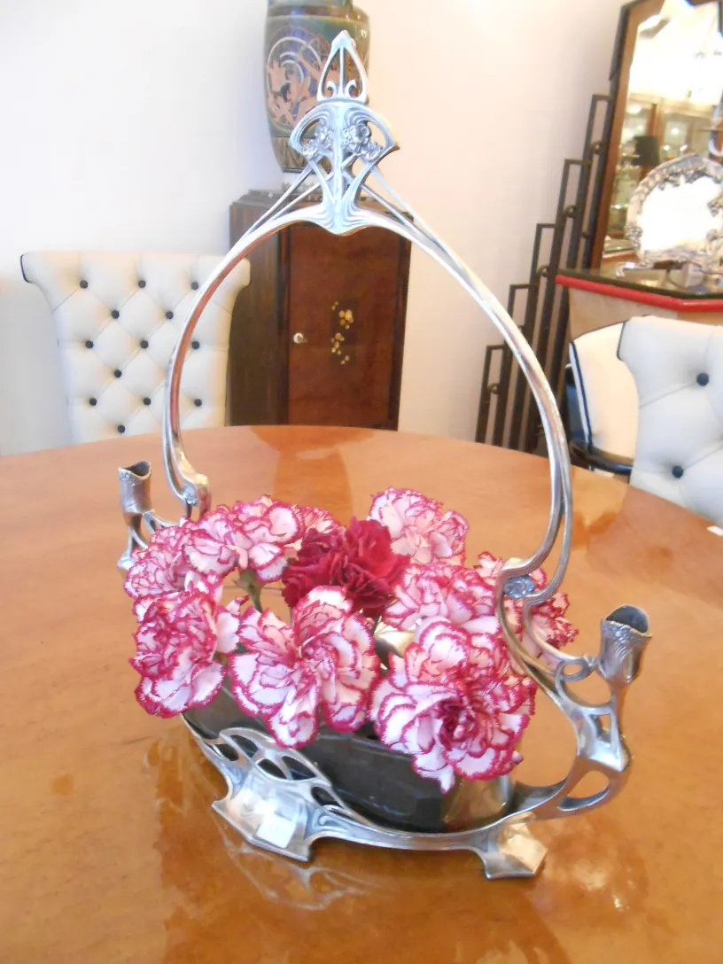 Centro de mesa antigo WMF com flores em um ambiente elegante.