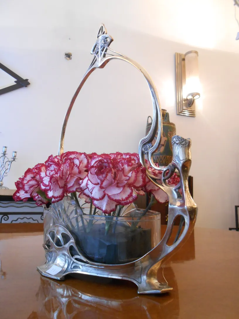 古いWMFセンターピースとピンクの花のある居心地の良い環境