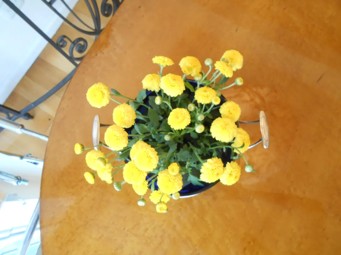 centro de mesa com flores amarelas sobre uma mesa de madeira, decoração antiga