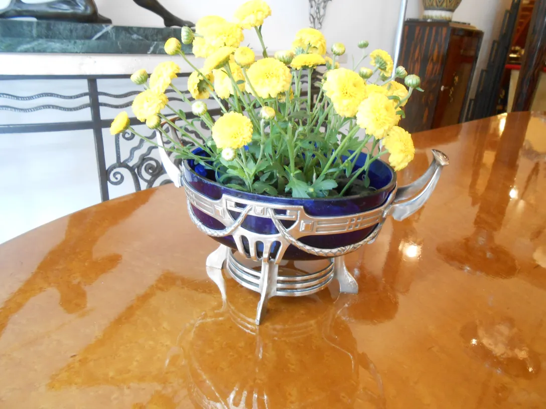 Centre de table WMF avec des fleurs jaunes sur une table brillante, antiquité décorative.
