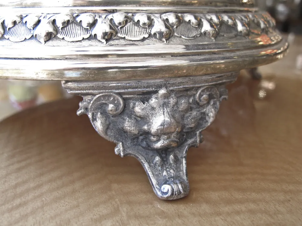 centre de table antique WMF avec décorations en relief et pieds en forme de lion, dans un environnement élégant