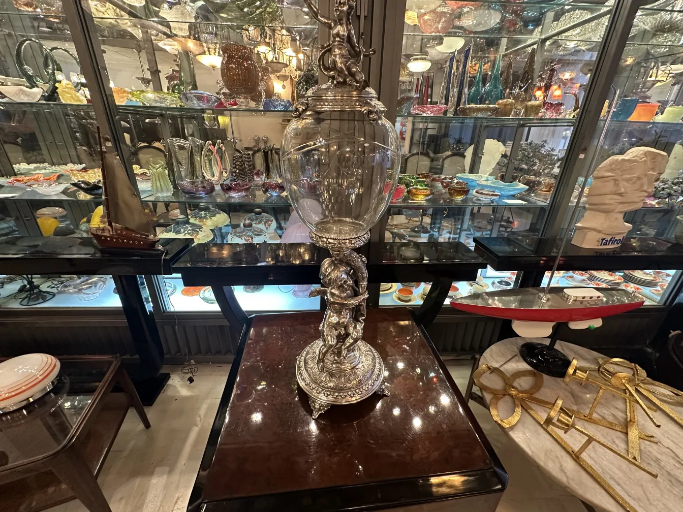 antique decorative centerpiece wmff with intricate details, surrounded by other decorative items