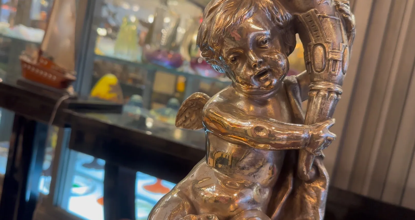 centro de mesa wmfs antigo com figura de anjo em ambiente elegante