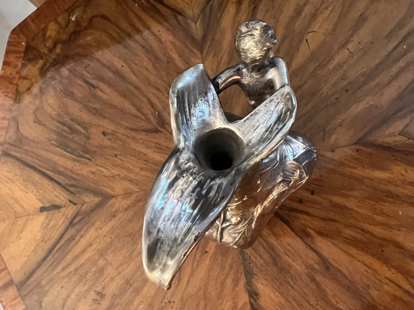 antique jar with a figure on top, placed on a wooden table